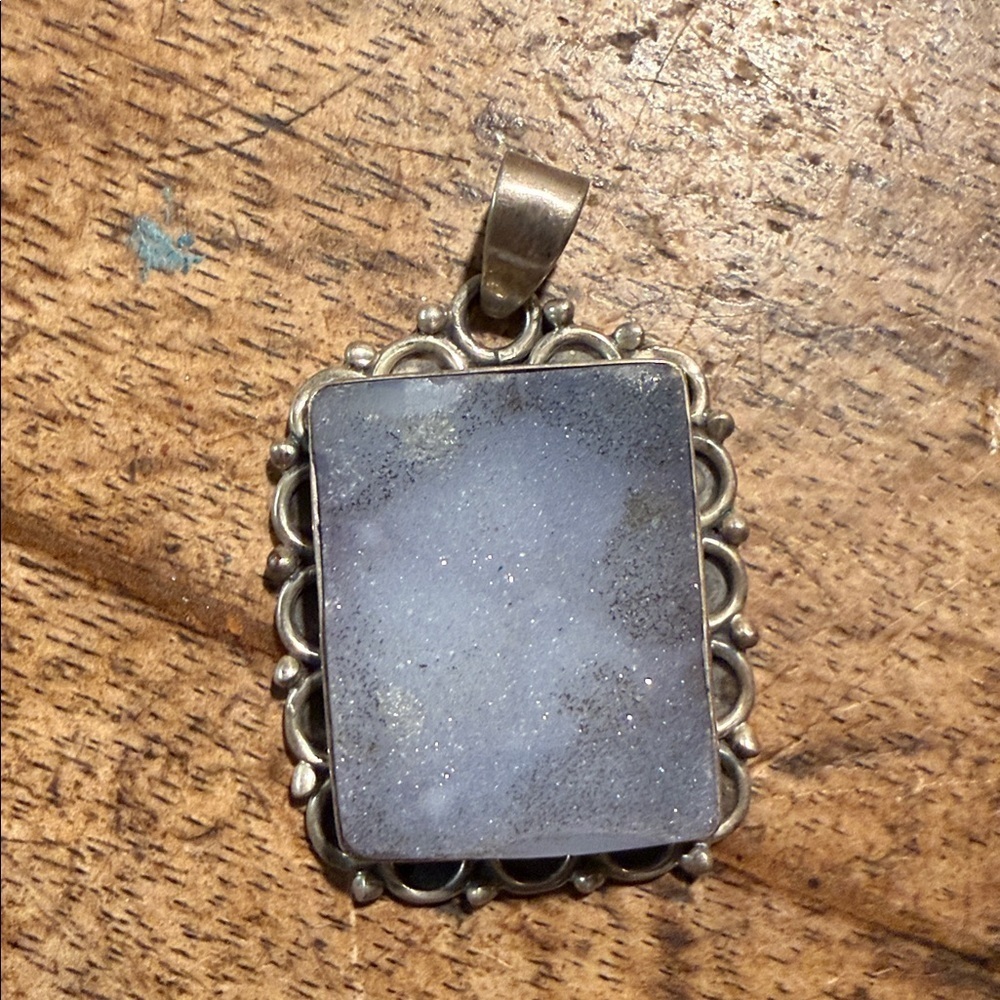 sterling silver pendant with a rectangular magical ornate bezel setting.